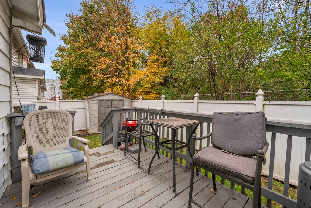 a patio with chairs and a table on a deck