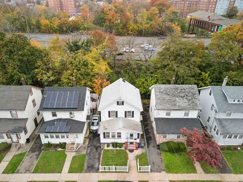 an aerial view of several houses with solar panels on their roofs