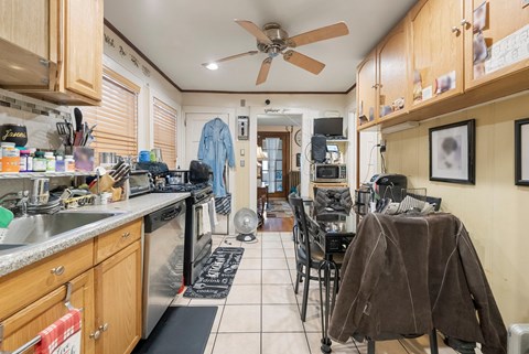a kitchen with a table and chairs and a stove and a ceiling fan