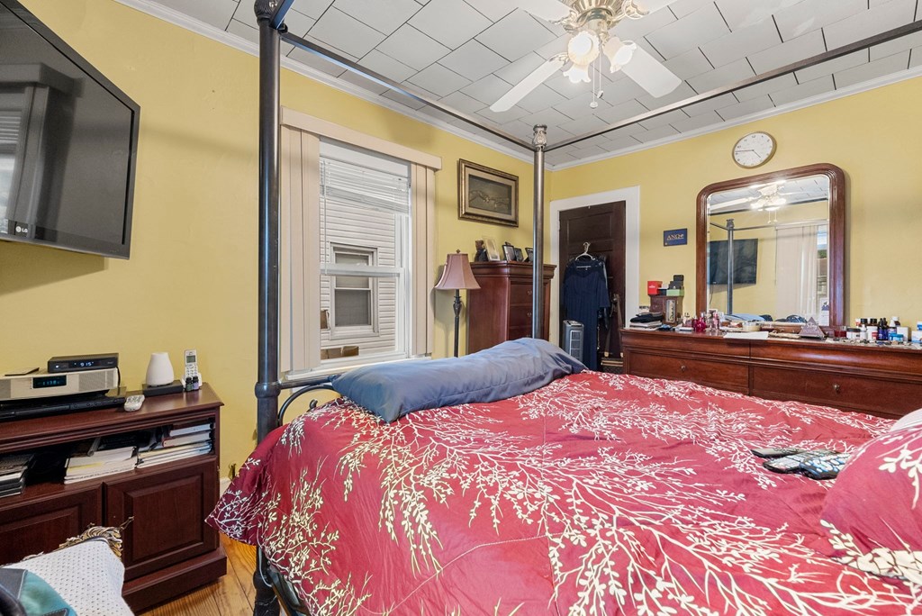 a bedroom with yellow walls and a bed with a red comforter