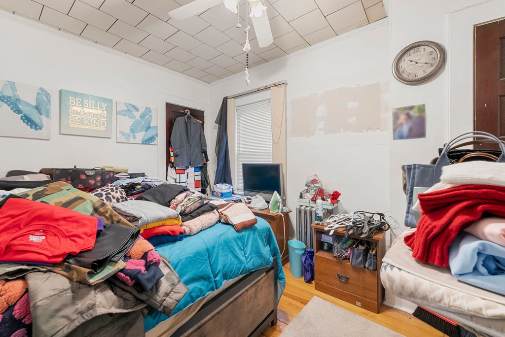 a bedroom with two beds and a lot of clothes in it