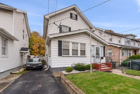 a white house with a car parked in front of it