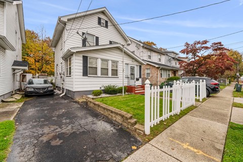 a white house with a white picket fence on a street