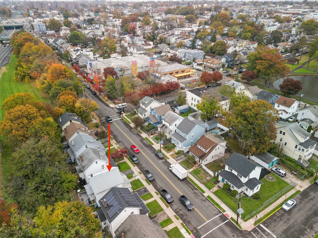 an aerial view of a neighborhood with cars on the street and trees
