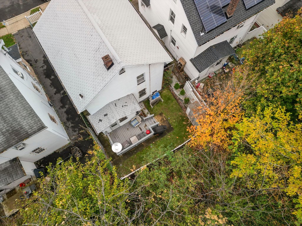 a birdseye view of a white house and a yard with a tree