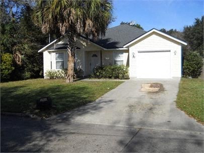 A white house with a garage door and a driveway.