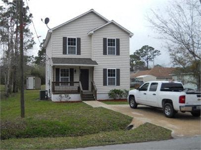 A white house with a porch and a truck parked in front.