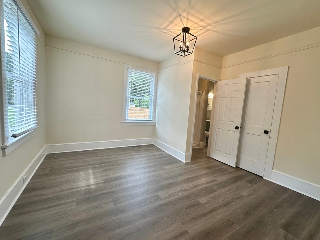 an empty living room with white walls and wood floors