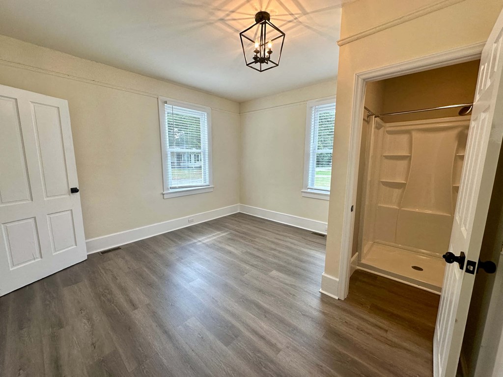an empty living room with a closet and a light fixture