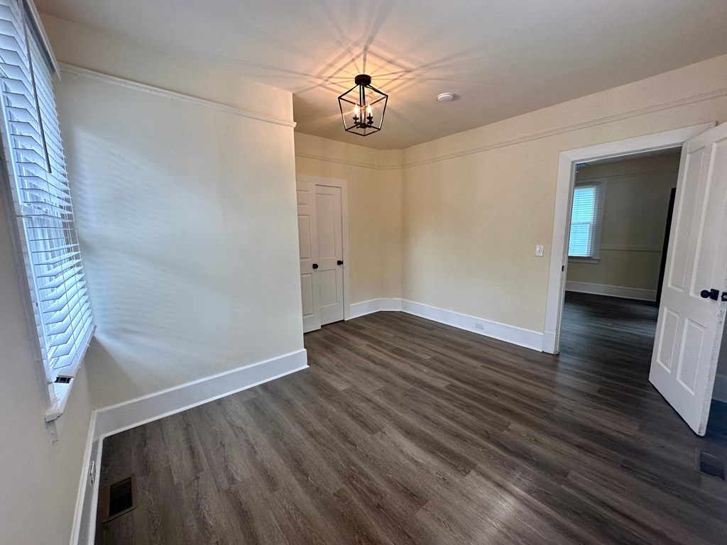 a renovated living room with white walls and wood flooring