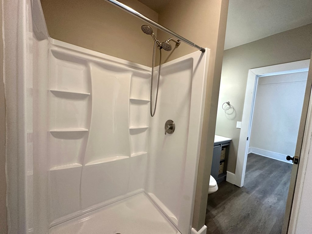 a bathroom with a shower and a toilet and a sink
