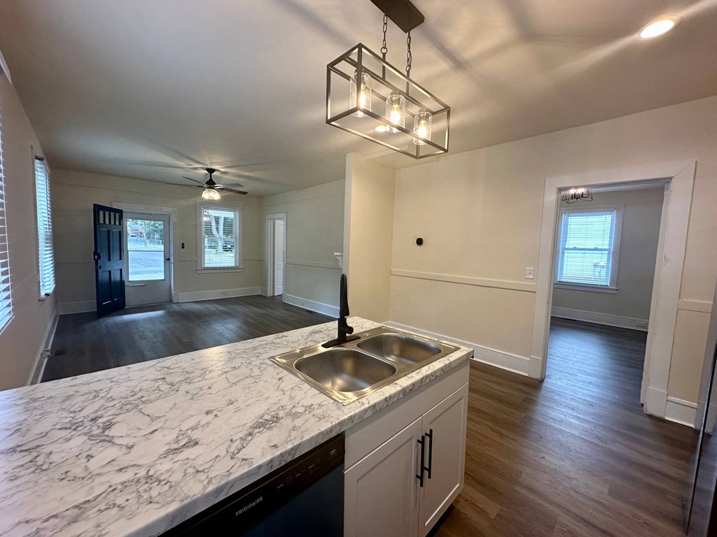 a kitchen with a sink and an empty living room