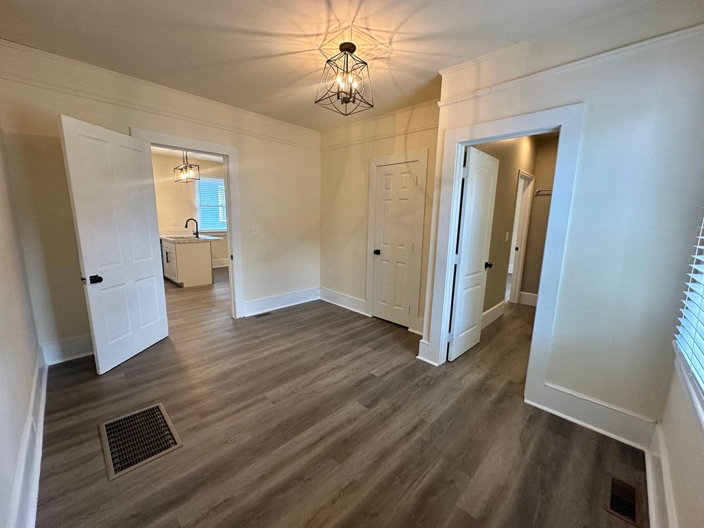 a renovated living room with white walls and wood floors