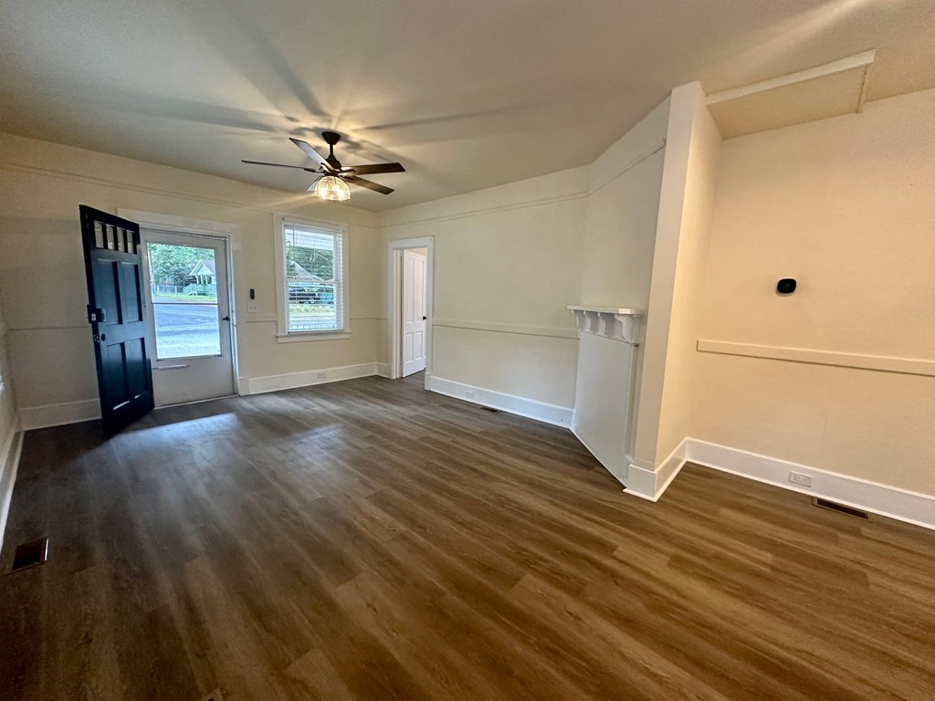 a living room with wood floors and a ceiling fan