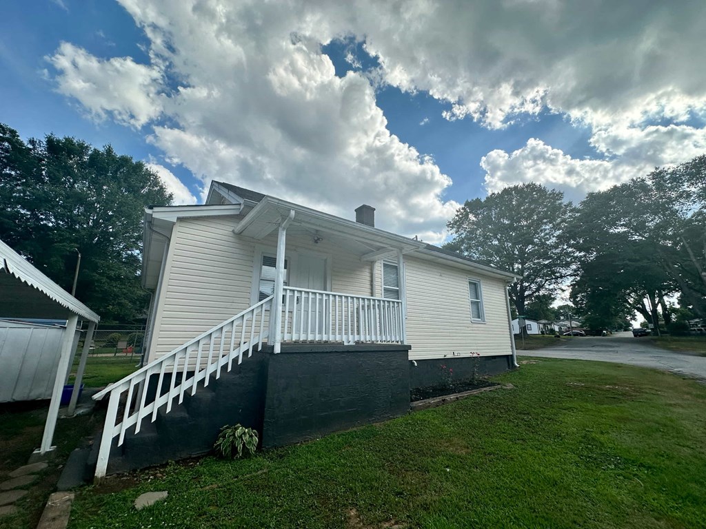 a white house on a hill with a cloudy sky