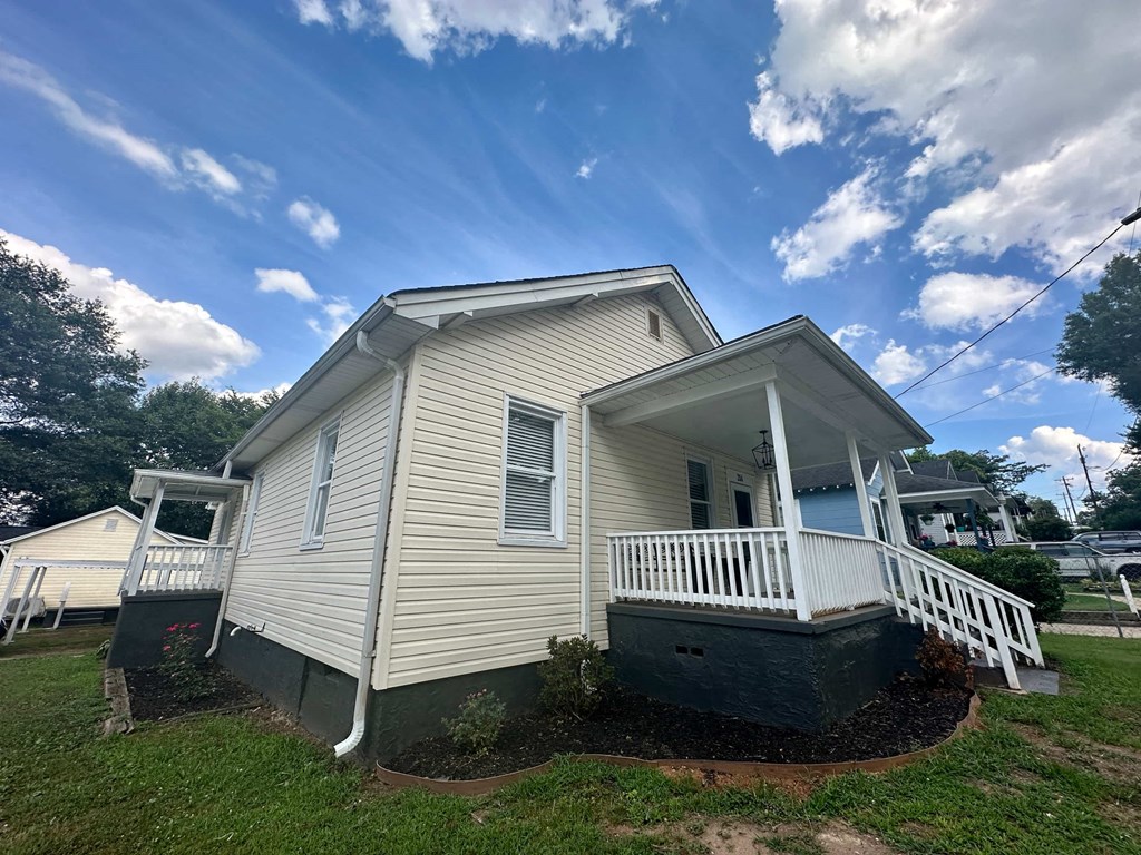 a white house with a porch and a blue sky