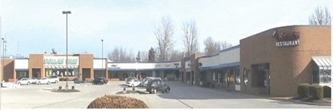 an old photo of a shopping center with cars parked in the parking lot