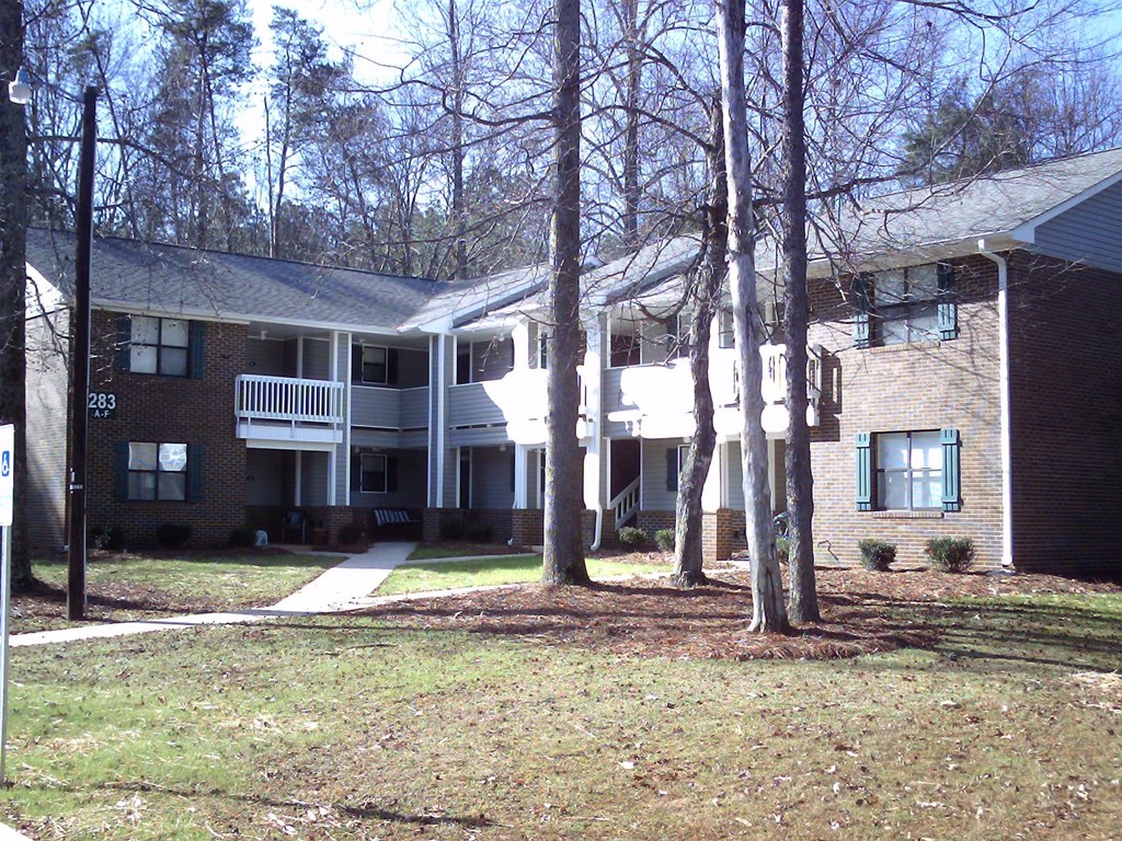 a view of an apartment building with trees in front of it