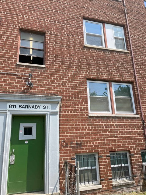the side of a brick building with a green door