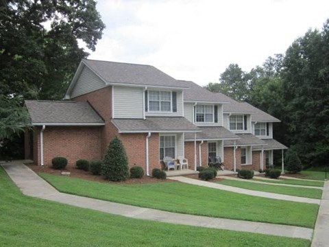 a brick house with a lawn in front of it