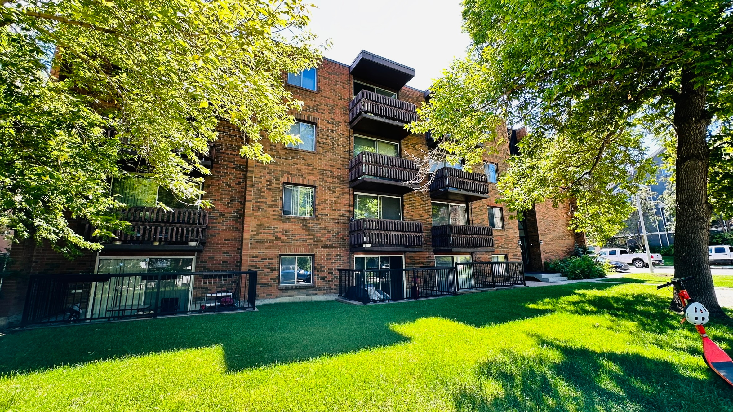 A red brick building with a green lawn in front.