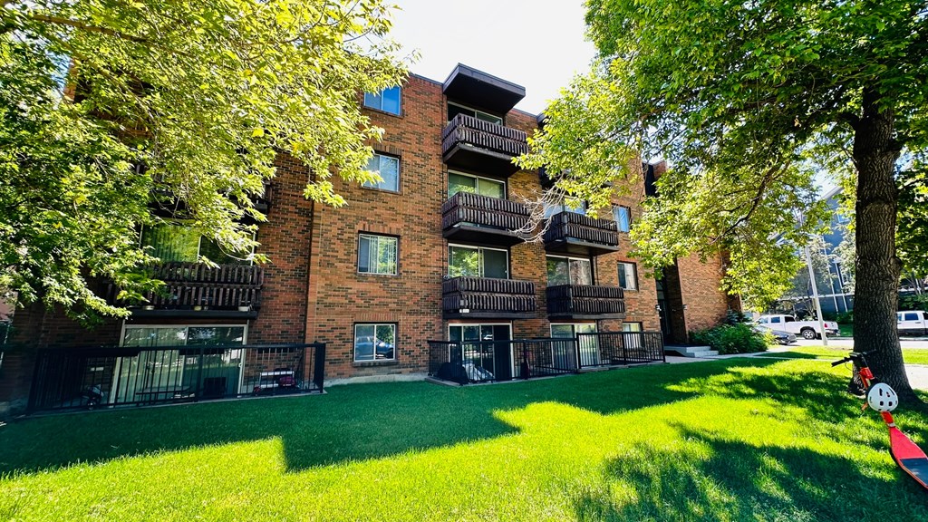 A red brick building with a green lawn in front.