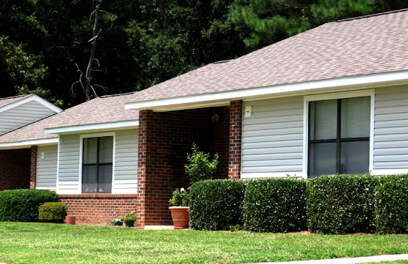 a white house with bushes in front of it