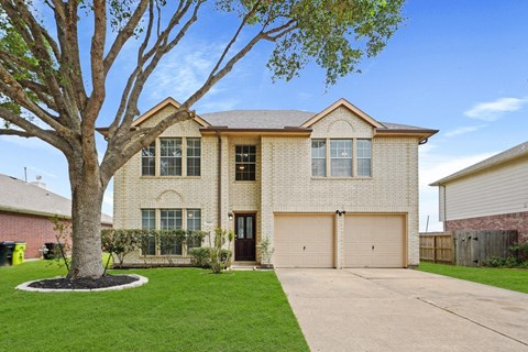 a white brick house with a tree in front of it