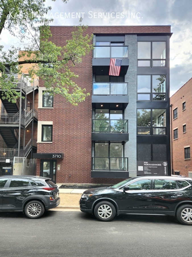 Two black cars are parked in front of a building with a sign that reads "ACCEPTANCE SERVICES INC.".