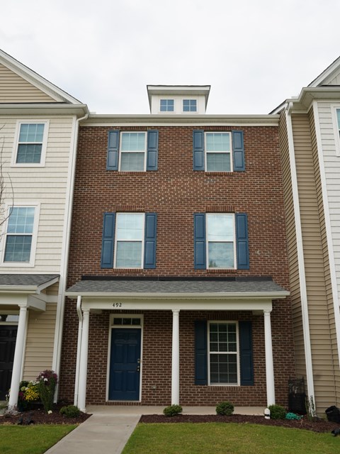 the front of a brick apartment building with blue doors and windows