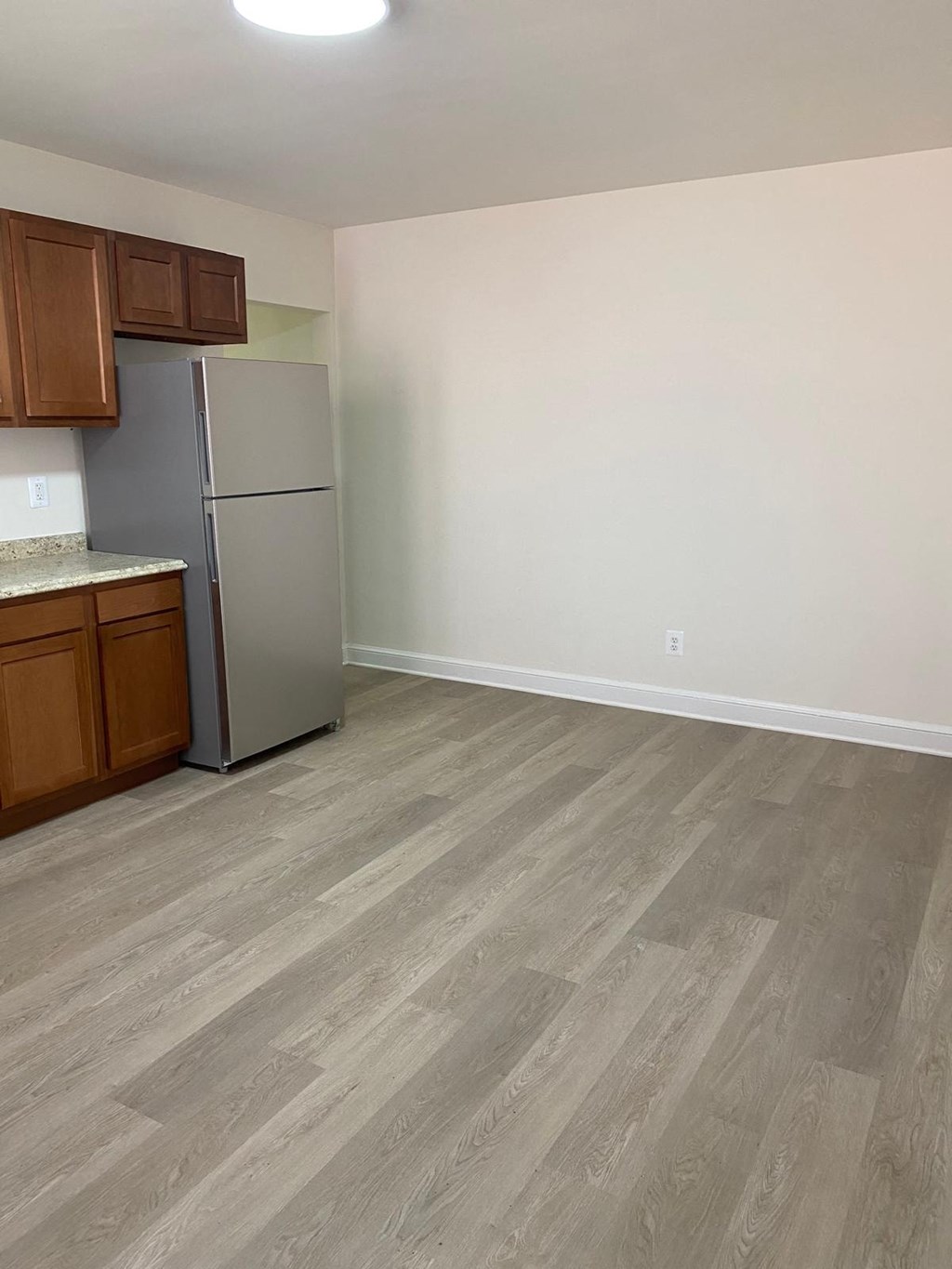 a kitchen with a refrigerator and wooden floors