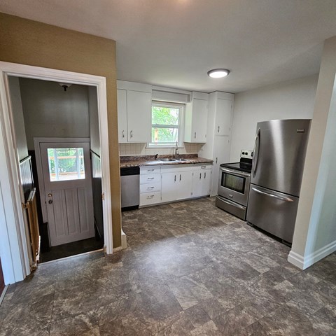 a kitchen with white cabinets and stainless steel appliances