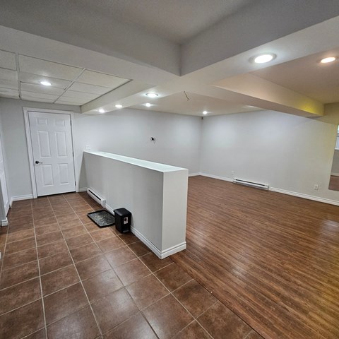 a living room with a partitioned wall and a wooden floor