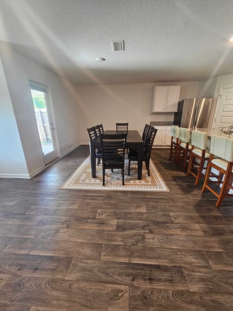 a living room and dining room with a table and chairs