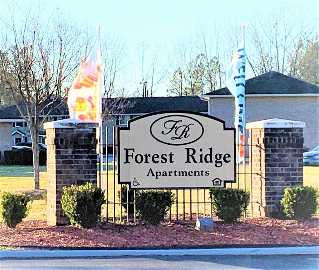 a sign for forest ridge apartments in front of a house