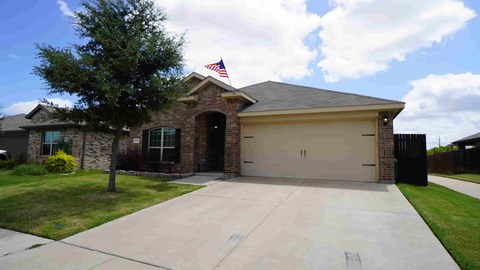 a house with a driveway and a flag on the roof