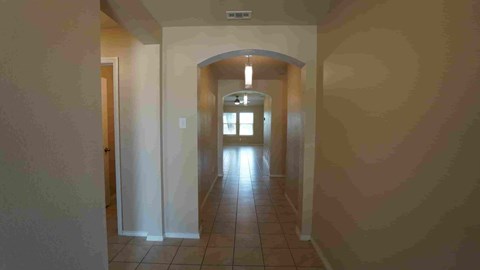 a look down a hallway with a tile floor