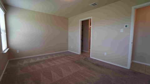 a empty living room with a door to a hallway