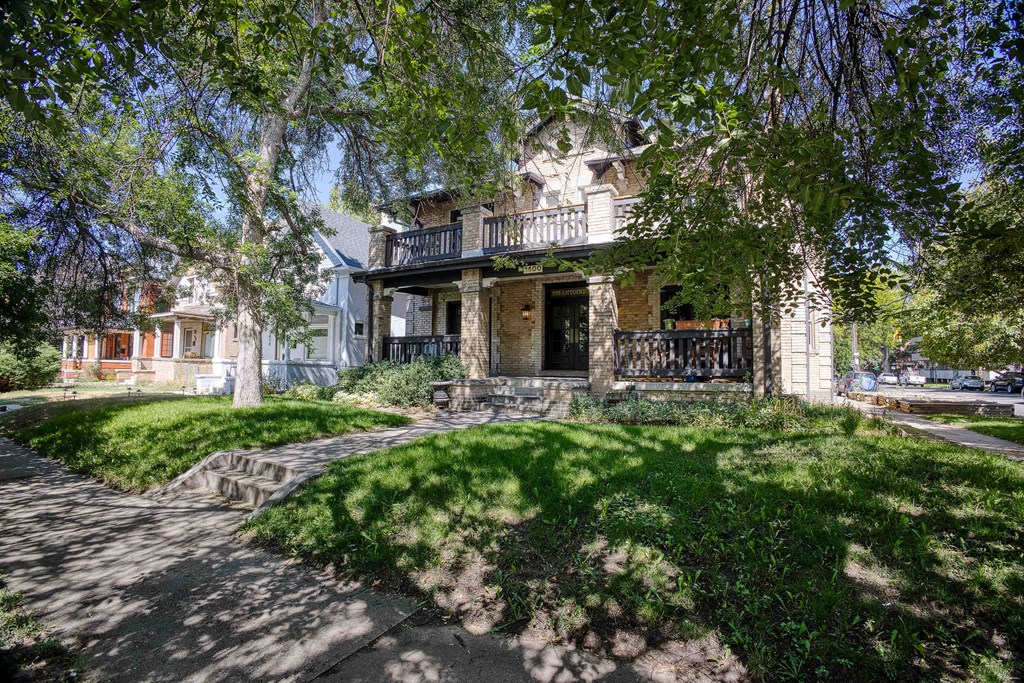 a house with a sidewalk and trees in front of it
