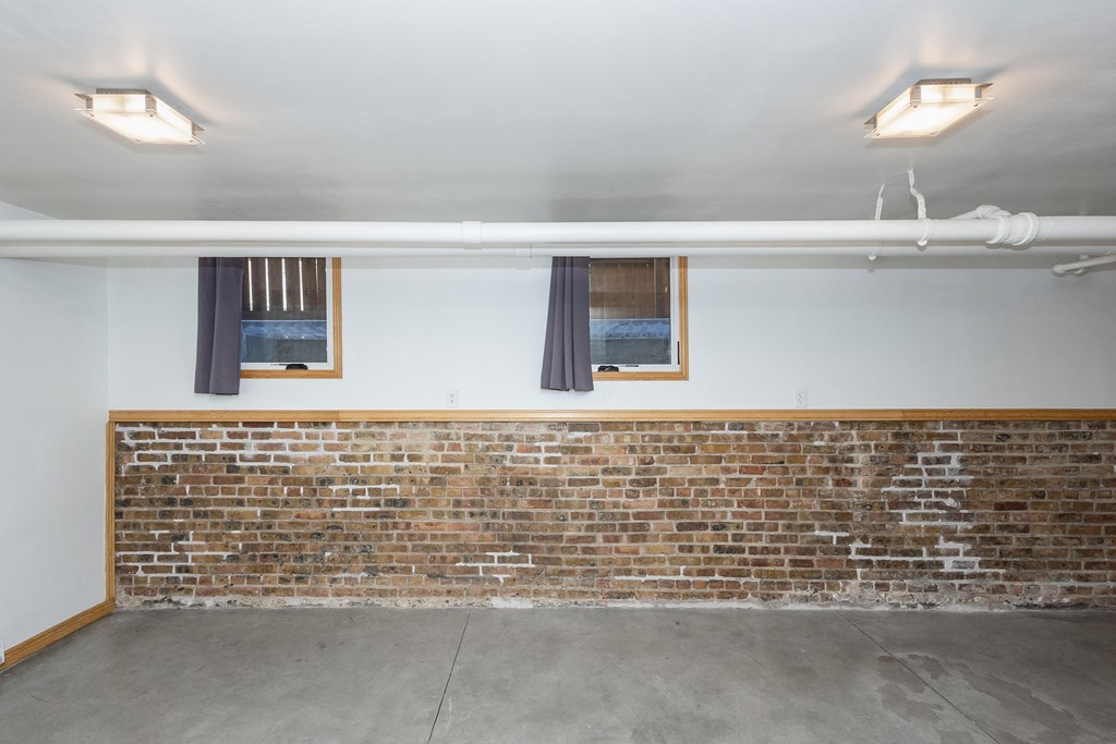 a garage with a brick wall and two windows