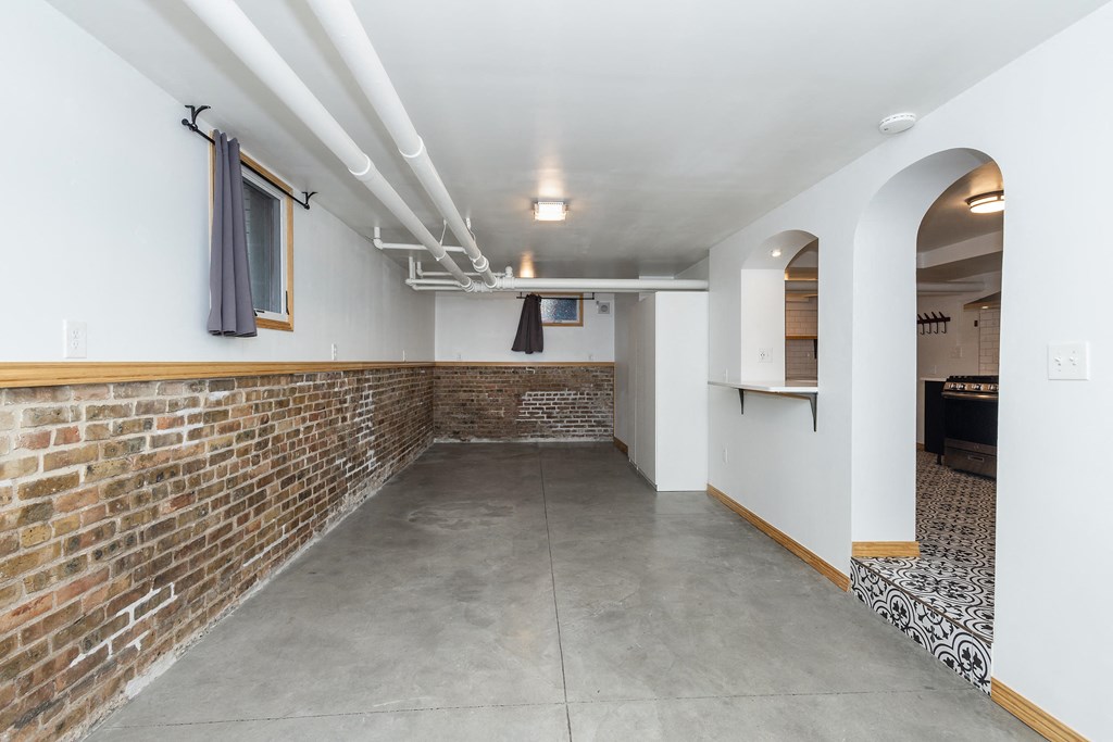 a long room with a brick wall and a concrete floor