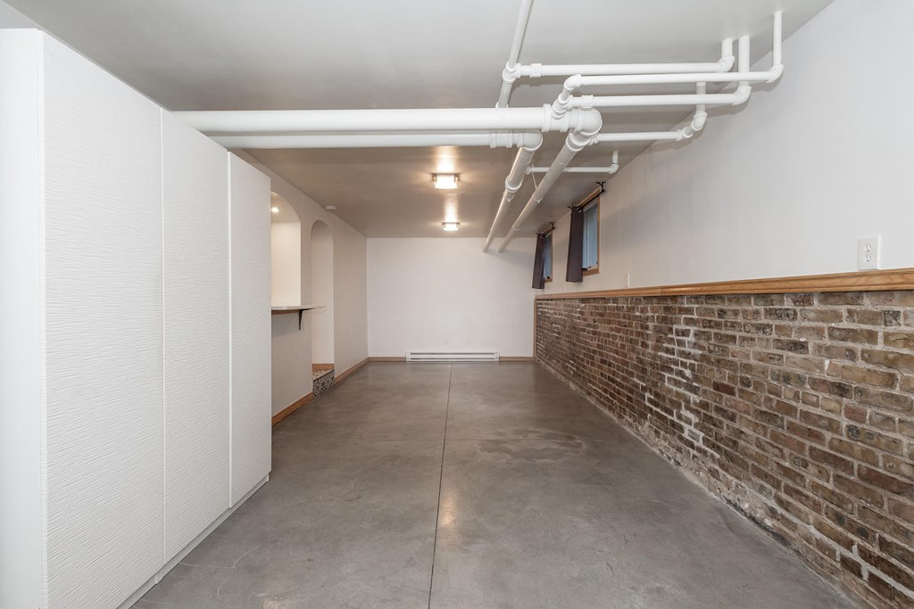 the interior of a room with a brick wall and a concrete floor