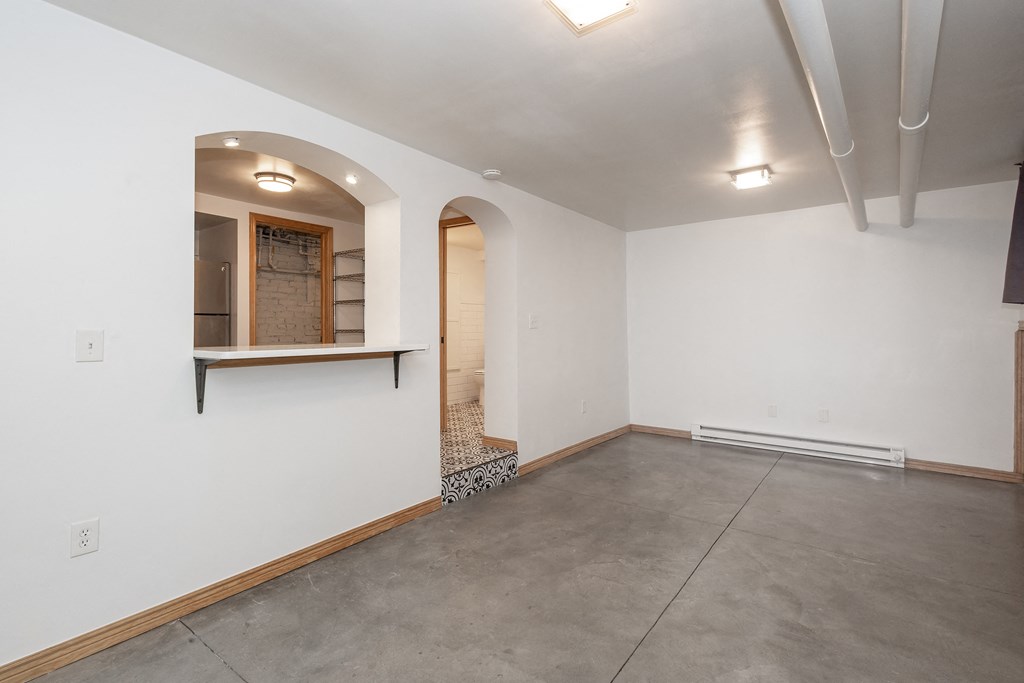 an empty room with white walls and a concrete floor