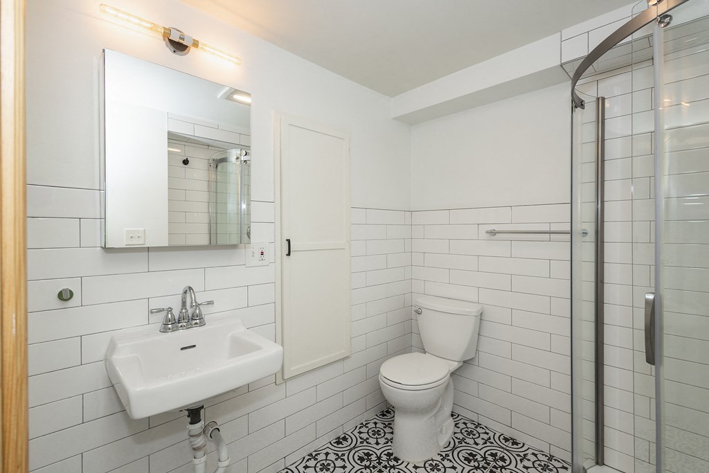 a bathroom with a toilet and a sink and a shower