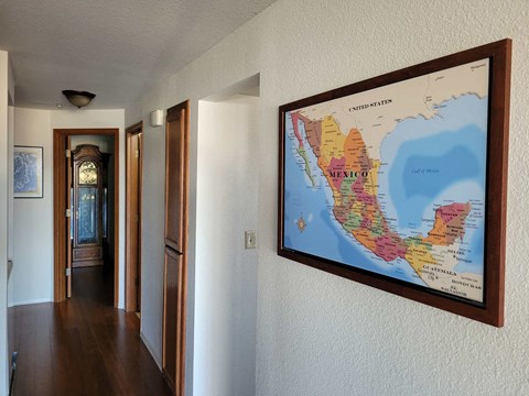 a map hangs on the wall in a hallway of a house