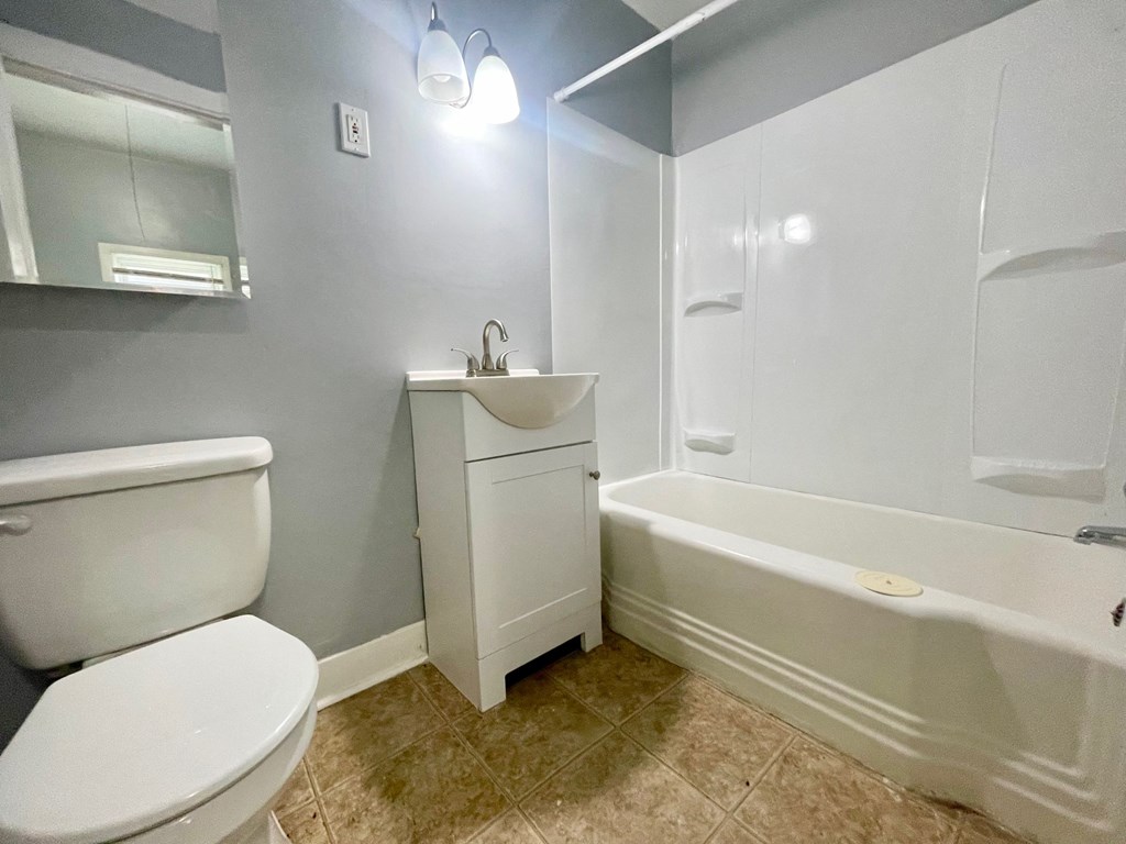 a bathroom with a toilet and a tub and a sink