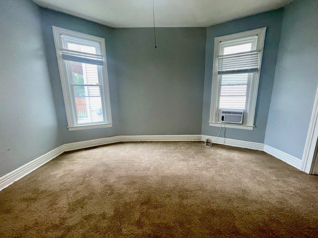 an empty room with blue walls and a brown carpet