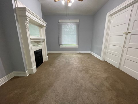 a bedroom with a carpeted floor and a fireplace