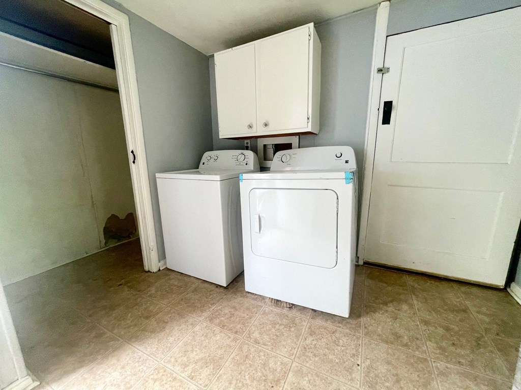 an empty laundry room with two washes and a dryer