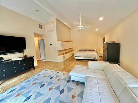 a large living room with a couch and a tv